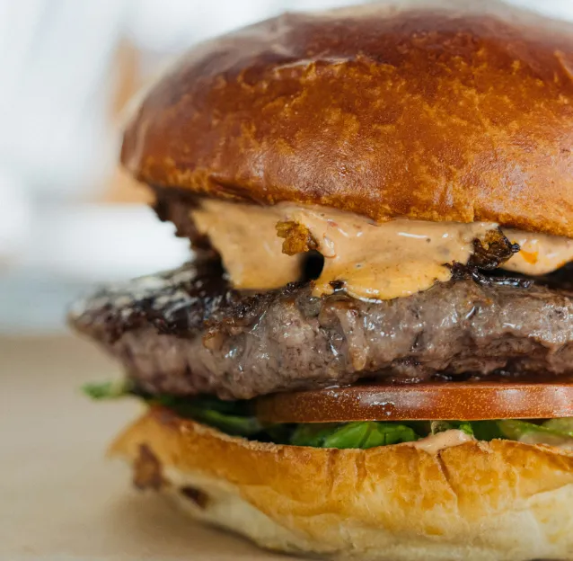 Vue de près d'un burger steak, fromage illustrant le travail de Ty'Djo, foodtruck de burgers dans les Côtes-d'Armor.