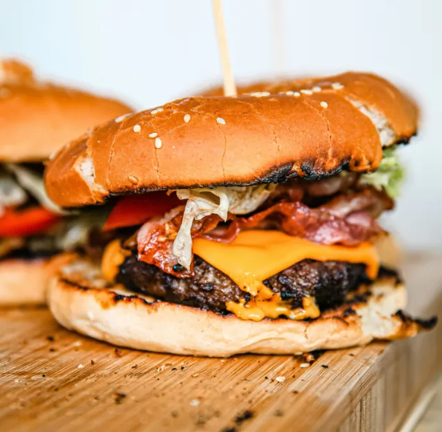 Vue de près d'un burger steak et bacon, illustrant le travail de Ty'Djo, foodtruck de burgers dans les Côtes-d'Armor.
