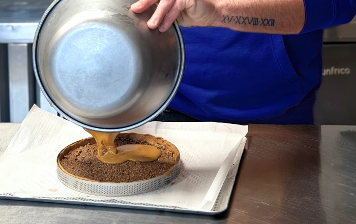 Jonathan, traiteur pâtissier événementiel dans les Côtes-d'Armor, en pleine préparation d'une tarte sucrée dans son atelier à Illifaut.