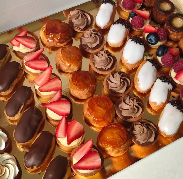 Plateau de mini pâtisseries (éclairs, tartelettes à la fraise, choux, cannelés) réalisé par Ty'Djo, traiteur pâtissier événementiel dans les Côtes-d'Armor.