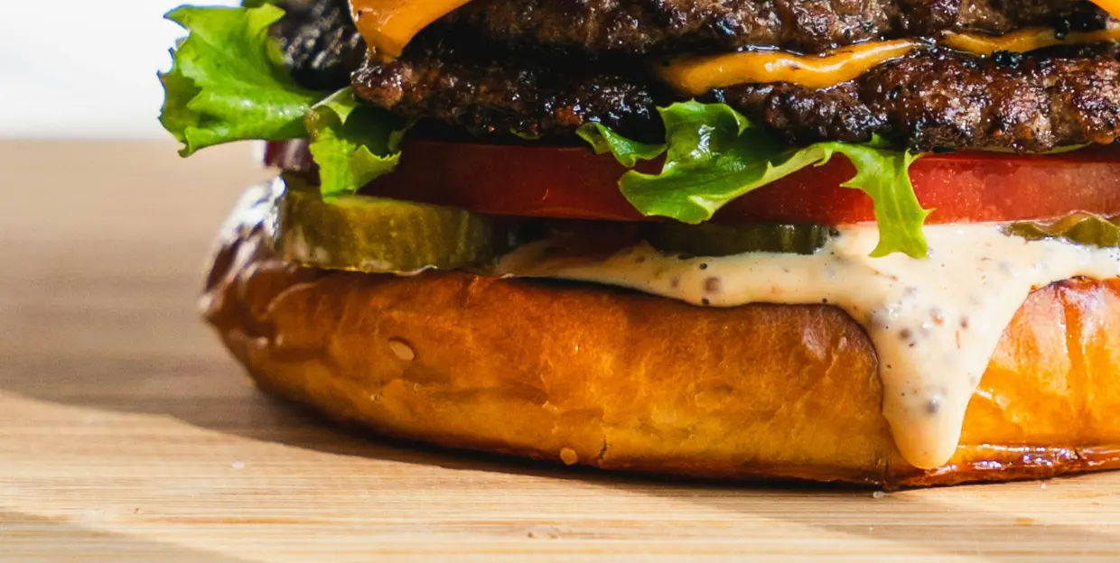 Vue de près d'un burger généreux illustrant le travail de Ty'Djo, foodtruck de burgers dans les Côtes-d'Armor.
