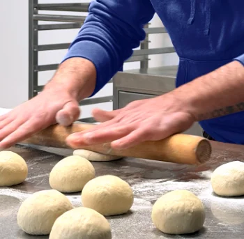 Jonathan, traiteur pâtissier et foodtruck dans les Côtes-d'Armor, en train d'étaler sa pâte artisanale dans son atelier.