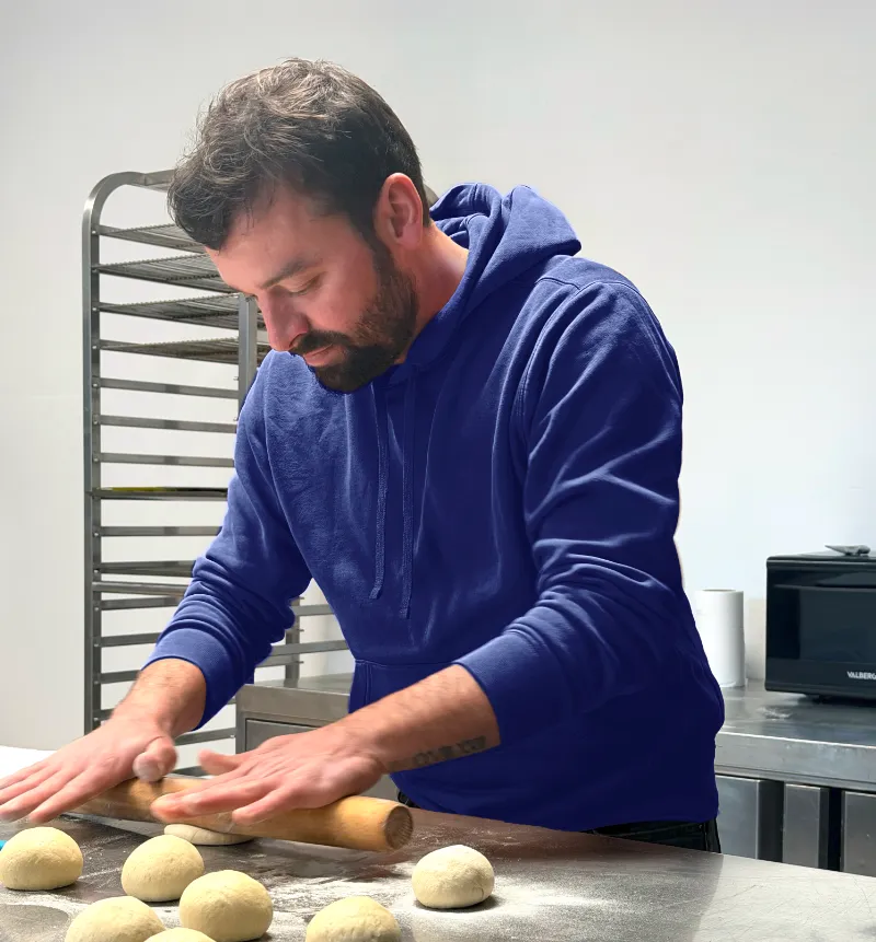 Jonathan, artisan traiteur pâtissier à Illifaut, dans son atelier préparant une pâte artisanale pour ses réalisations culinaires.